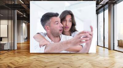 happy couple using mobile phone at home Wall mural