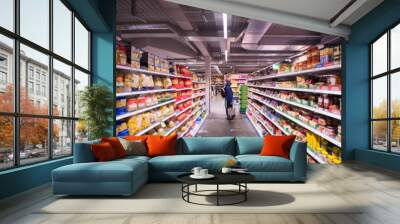 Man shopping in modern supermarket Wall mural