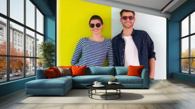 Modern man and girl wearing sunglasses posing isolated in front of colorful background Wall mural