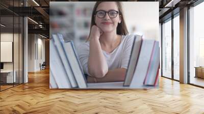 portrait of famale student selecting book to read in library Wall mural