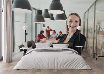 Portrait of happy businesswoman owner in modern office. Businesswoman smiling and looking at camera. Busy diverse team working in background. Leadership concept. Head shot. Wall mural