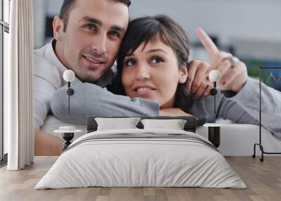 Relaxed young  couple watching tv at home Wall mural