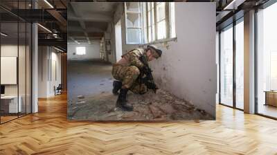 soldier in action near window changing magazine and take cover Wall mural