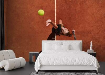 Top view of a professional female tennis player serves the tennis ball on the court with precision and power Wall mural