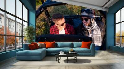 two young men driving a off road buggy car Wall mural