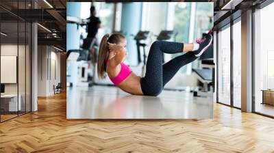 woman stretching and warming up for her training at a gym Wall mural