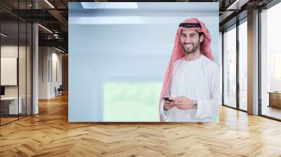 young arabian businessman using smartphone at home Wall mural