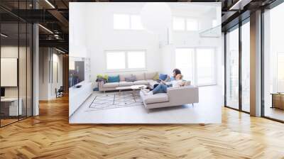 Young couple on the sofa watching television Wall mural