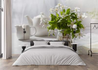 A beautiful bouquet of snowdrops in a glass vase near the window on the windowsill Wall mural