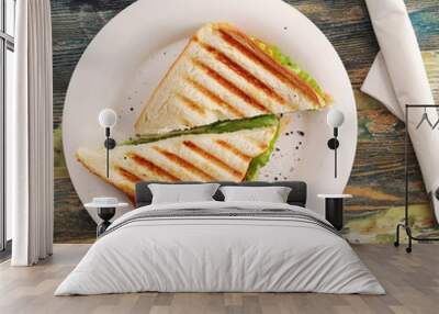 Two sandwiches on white plate, wooden background. Wall mural