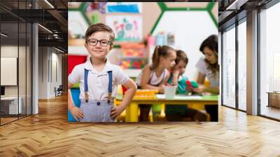 Preschooler posing at camera in classroom. Wall mural