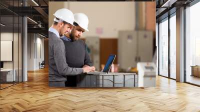 two businessman working with laptop in factory Wall mural