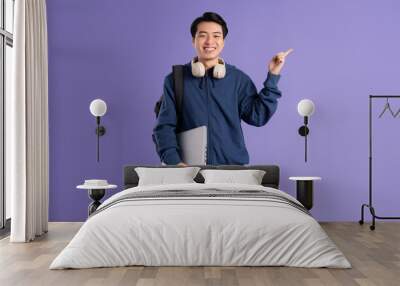 Asian male student portrait on purple background Wall mural