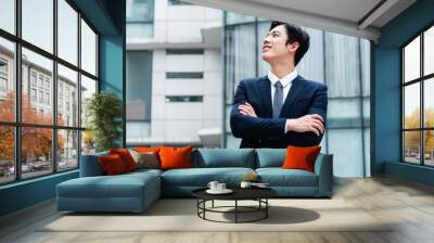 Image of Young asian businessman with glass building background Wall mural