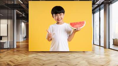 Portrait of adorable asian boy posing on yellow background Wall mural