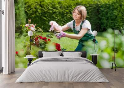 Young smiling woman florist working in the garden Wall mural