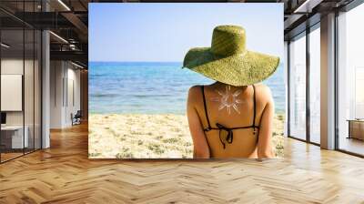 woman on beach with sun symbol on her back Wall mural