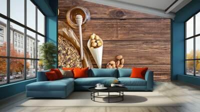 Large round cereal and nut cake with mix nuts and honey on wooden background, healthy eating concept Wall mural