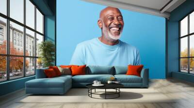 Blue november happy afro senior bald headed white bearded man wearing a light blue t shirt on blue background Wall mural