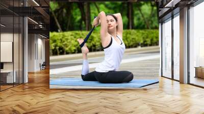 Healthy young woman enjoying and relaxing yoga outdoor in green park Wall mural