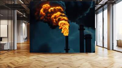 Industrial chimney emitting smoke and flames against a dark sky, highlighting environmental pollution and industrial impact. Wall mural