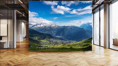 Scenery view of Verbier village surrounded with beautiful Swiss Alps mountains in sunny summer day with green meadows, forests, blue sky. Wall mural