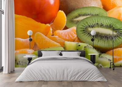 An abundance of of fruit on the table. Kiwi, tangerines and pers Wall mural