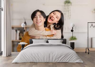 Asian young couple hugging with positive emotion and loving together at warmth place. Attractive man and woman embracing spending time together at home. Couple love and Valentine's Day concept Wall mural