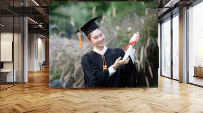 Attractive Asian Women Student Graduate in cap and gown celebrating with certificate in hand and so proud happiness in Commencement day,Congratulation of student in graduation day,Education Success Wall mural