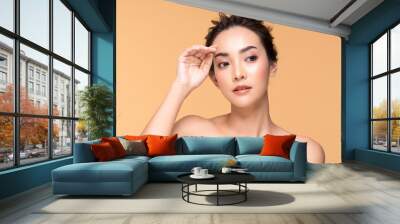 Beautiful Asian woman touching eyebrow smile with clean and fresh skin Happiness and cheerful with positive emotional,isolated on Beige background,Beauty Cosmetics and spa Facial treatment Concept Wall mural