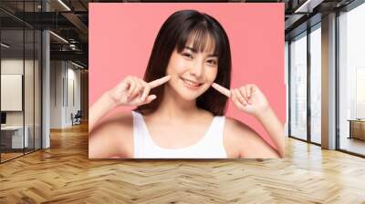 Beautiful Asian woman touching soft cheek smile with clean and fresh skin Happiness and cheerful with positive emotional,isolated on pink background,Beauty Cosmetics and spa Treatment Concept Wall mural