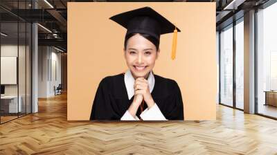 Beautiful Attractive Asian woman graduated in cap and gown smile so proud and happiness,Isolated on Beige background,Education Success Concept Wall mural