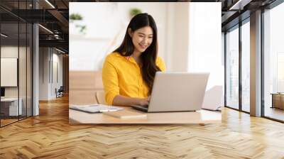 Entrepreneur beautiful business asian young woman wear yellow shirt work online with laptop at home.Freelance woman working online sale marketing at home.Small Business Startup concept.Tracking Shot Wall mural