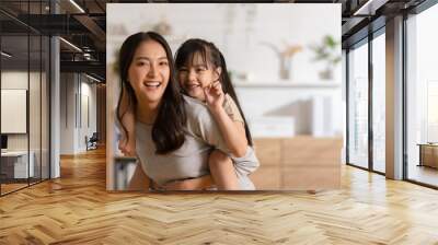 Happy asian mom holding her daughter playing together at home.little girl hugging her mother smile and love having fun at home.Mother day concept Wall mural