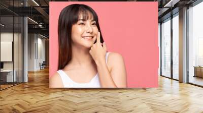 Young Beautiful Asian woman smile touching soft cheek with clean and fresh skin Happiness and cheerful with positive emotional,isolated on pink background,Beauty Cosmetics and spa Treatment Concept Wall mural