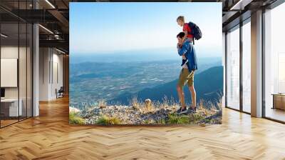 Father with child walking on the mountain and enjoying scenic view from the mountain top Wall mural