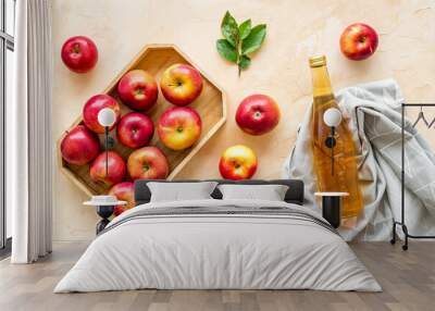 Apple cider vinegar in glass bottle and wooden tray with red apples Wall mural