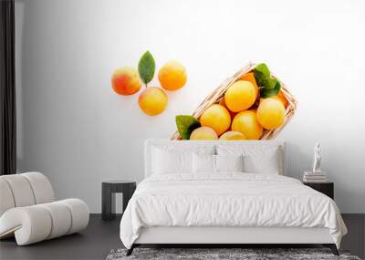 Fresh raw apricots in basket on white background top view copy space, pattern with leaves Wall mural