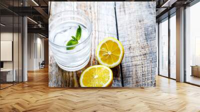 glass of water with lemon and mint on wooden table Wall mural