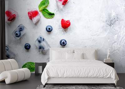 ice cubes with berries and mint on stone top view mock up Wall mural