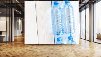 Plastic bottles with pure water on white wooden background top v Wall mural