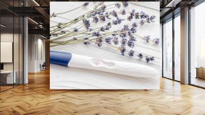 Positive pregnancy test with lavender on wooden background Wall mural