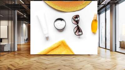 Towel, sun lotion, glasses on white background top view Wall mural