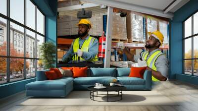 Two African workers working in a warehouse Organize the product system with a forklift truck. transportation industry. Wall mural