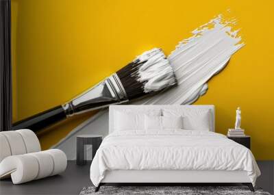 A brush that paints white paint on a yellow wall Wall mural