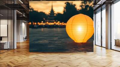 A lit lantern sits on the ground in front of a large crowd of people Wall mural