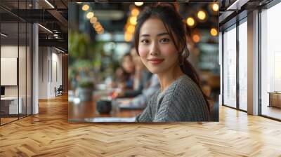 A woman with a smile on her face is sitting at a table with other people Wall mural