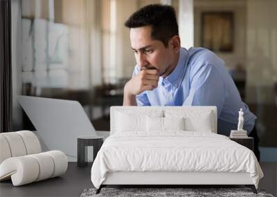 A young businessman using laptop standing working with happy in modern office. Wall mural