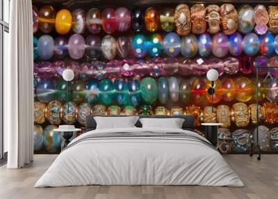 A box filled with a variety of differently colored beads, creating a vibrant and colorful display. Each bead is unique in size, shape, and hue, making for a visually striking collection. Wall mural