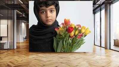 A young Saudi boy from the Arab Middle East hides a bouquet of flowers behind his back preparing to surprise his mom on Mother s Day The scene is set against a crisp white background perfec Wall mural